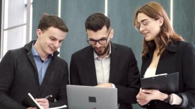 Ofiste bir proje üzerinde çalışan üç iş arkadaşı.