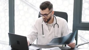 Ofisinde X-ray 'e bakan bir tıp çalışanı.