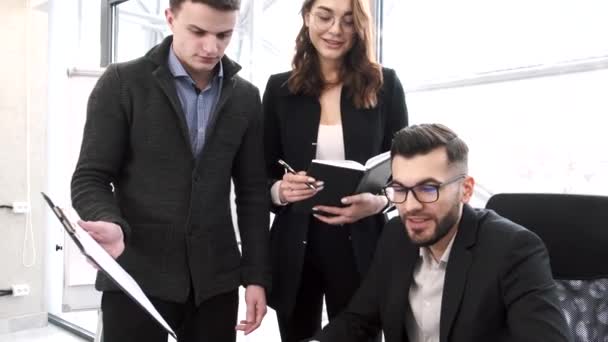 Tři spolupracovníci pracují na projektu v kanceláři — Stock video