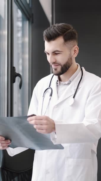 Медицинский работник смотрит на рентген в своем офисе — стоковое видео