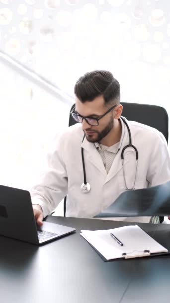 Mediziner schaut sich Röntgenbild in seinem Büro an — Stockvideo