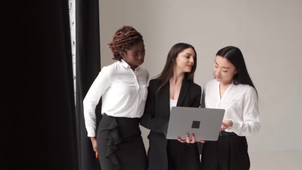 Diverse colege de sex feminin în picioare cu laptop pe backgroud alb — Videoclip de stoc
