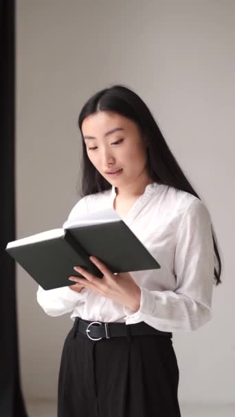Asiatique femme lecture un livre dans blanc chambre — Video