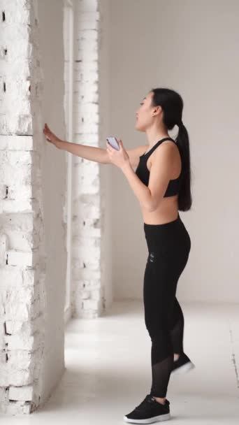 Молодая женщина делает растяжку на белой заднице — стоковое видео