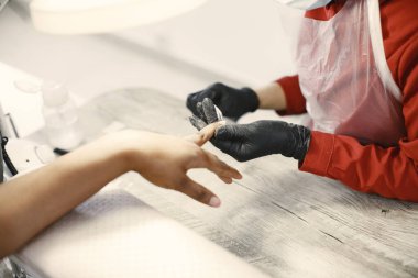 Afrikalı bir kız güzellik salonunda manikür yapıyor.