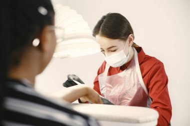 Afrikalı bir kız güzellik salonunda manikür yapıyor.