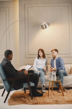 Psikolog randevusundaki çift modern ofiste oturuyor.