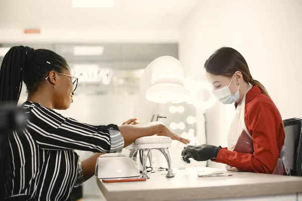 Chica africana haciendo manicura en un salón de belleza — Foto de Stock