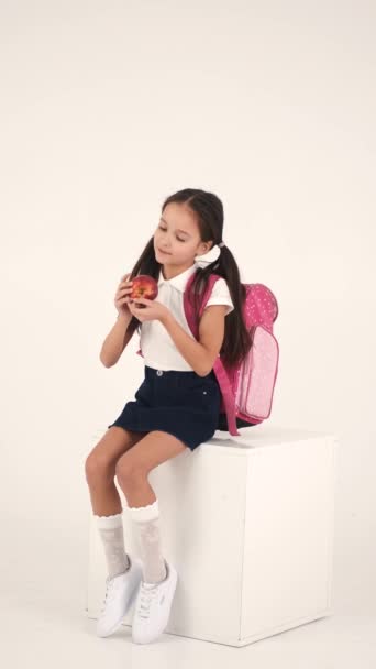 Menina alegre com mochila sentada em estúdio — Vídeo de Stock