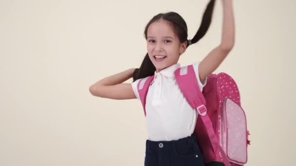 Malá školačka s batohem a uniformou na bílém hřbetě — Stock video
