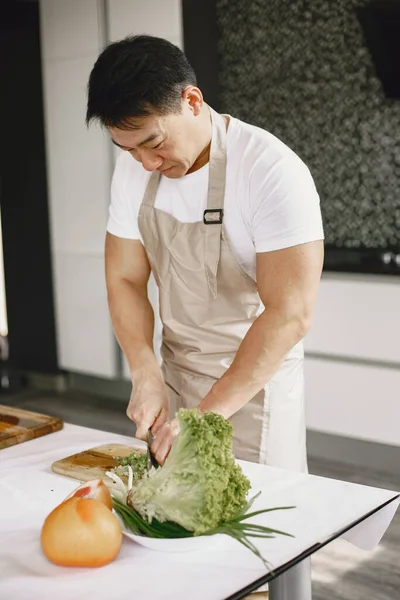 L'uomo asiatico prepara la cena in cucina — Foto Stock