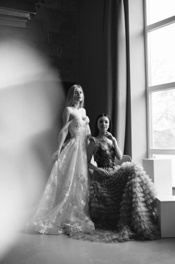 Stüdyoda zarif bir elbise içinde poz veren güzel kadınlar.