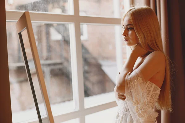 Die schöne junge Frau posiert in einem Hochzeitskleid — Stockfoto