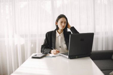 Takım elbiseli bir kız çatı katında çalışıyor.