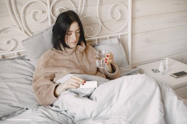 Kadın hasta ve battaniyenin altında yatıyor.