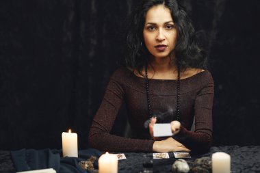 Karanlık bir odada bir falcının portresi.