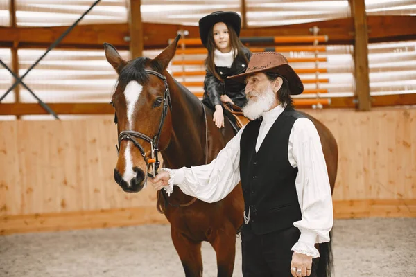 Маленький ребенок едет на лошади с инструктором — стоковое фото