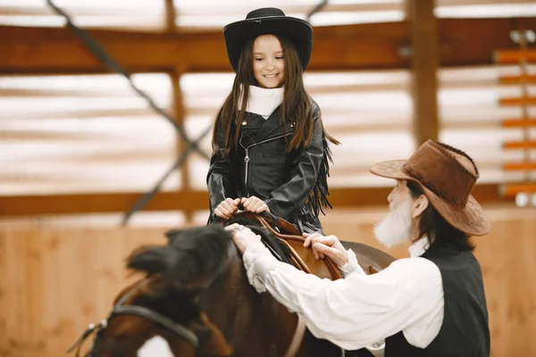 Маленький ребенок едет на лошади с инструктором — стоковое фото