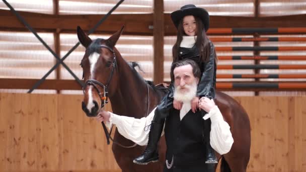 Senior man carrying granddaughter on shoulders and leading horse — Αρχείο Βίντεο