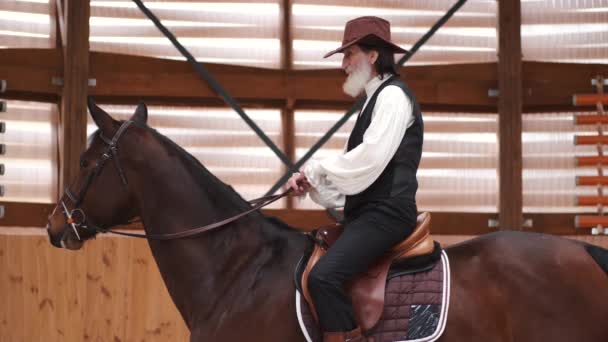 Old cowboy in a hat riding a horse — стоковое видео