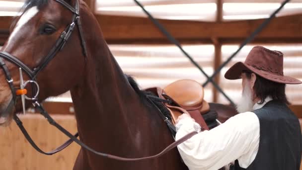 Old cowboy in a hat riding a horse — Vídeos de Stock