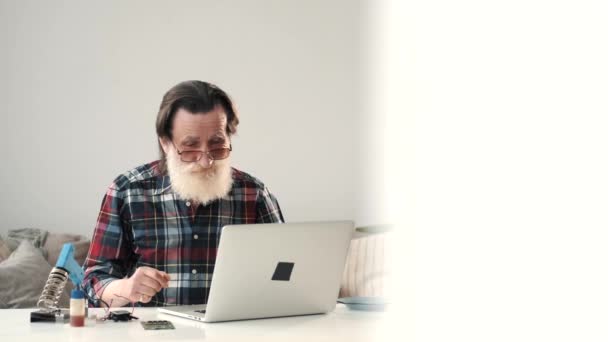 Homem sênior moderno trabalhando no laptop em casa — Vídeo de Stock