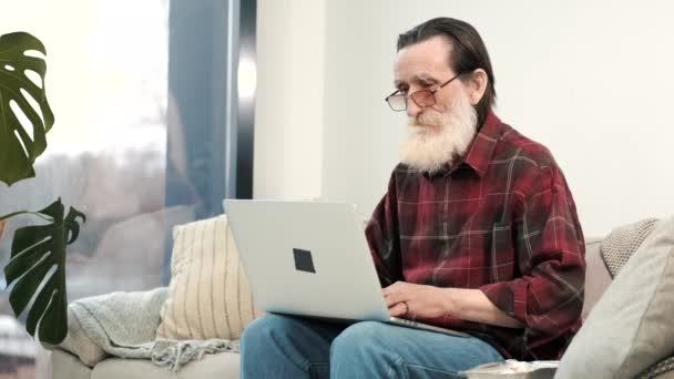 Pria senior modern yang bekerja pada laptop di rumah — Stok Video