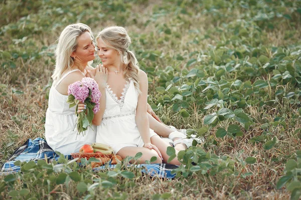 Madre con hermosa hija en un campo de otoño —  Fotos de Stock