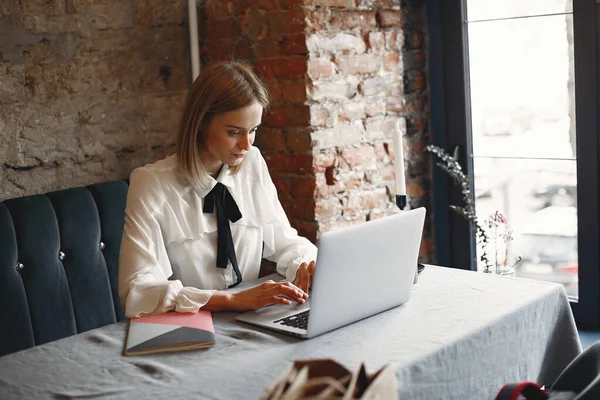 Businesswoman sitting at the table with a laptop — Stock Photo, Image