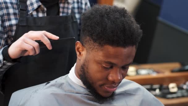 Joven afroamericano visitando peluquería para cortarse el pelo — Vídeo de stock