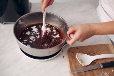 Beyaz elbiseli şef çikolatalı pasta hazırlıyor..