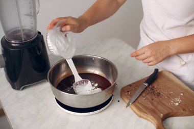 Beyaz elbiseli şef çikolatalı pasta hazırlıyor..