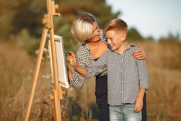 Matka se synem malují na poli — Stock fotografie