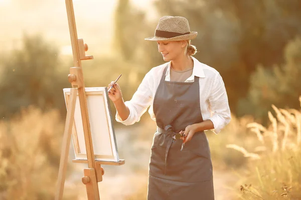 Mulher em um avental pintura em um campo — Fotografia de Stock