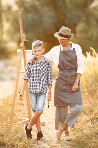 Madre con hijo pintando en un campo — Foto de Stock