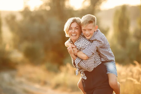 Anne ve küçük oğlu bahar tarlasında yürüyorlar.