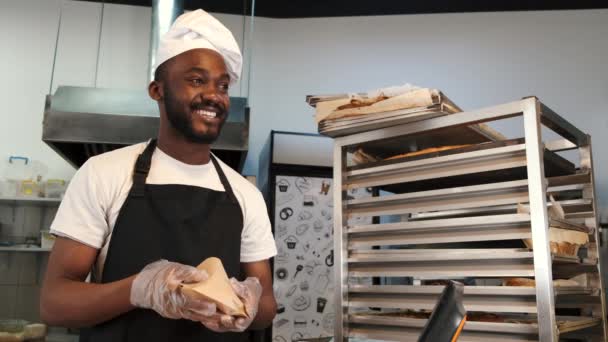 Afroamerikansk bagare i enhetlig sortering av bakade produkter på lastpallar — Stockvideo