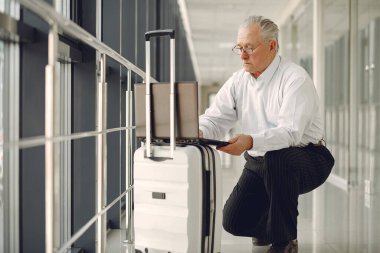 Havaalanında bavullu şık bir yaşlı adam.