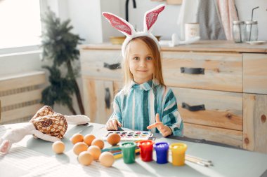 Küçük kız bir mutfakta oturmuş