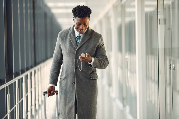 Eleganter schwarzer Mann mit Koffer am Flughafen — Stockfoto