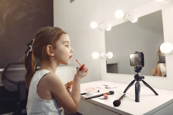 Cute little blogger with cosmetics recording video at home — Stock Photo, Image