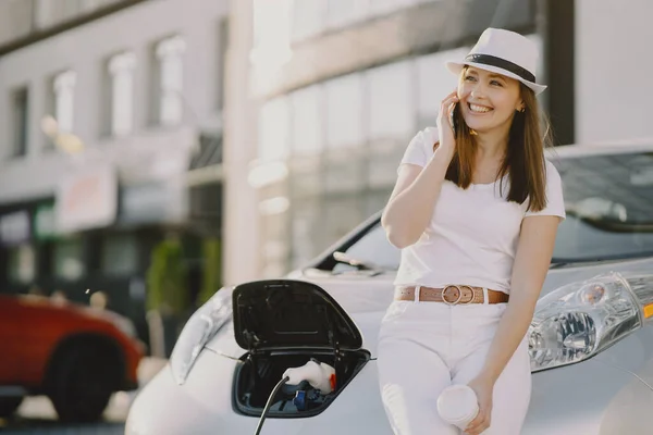 Vrouw opladen electro auto bij het elektrische benzinestation — Stockfoto