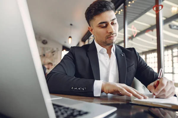 Stylish businessman working in a cafe and use the laptop — Stock Photo, Image