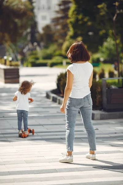 Mãe com filha em um parque de primavera com patins — Fotografia de Stock