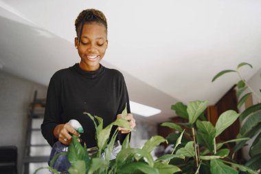 Afrikalı kadın büyük bitkilerle ilgileniyor.