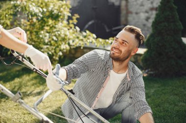 Çim biçme makinesi sahipleri arka bahçede çalışıyor.