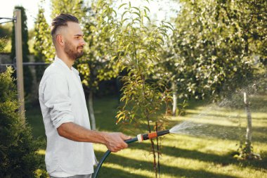 Bahçede çimleri sulayan adam