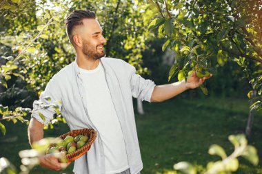 Elma sepeti tutan gülümseyen çiftçinin portresi