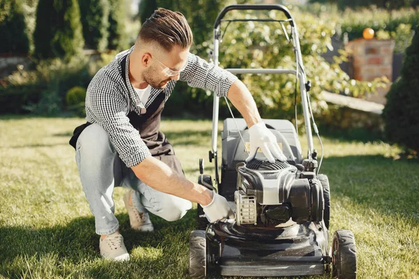 Man repairs lawnmover in a backyard — Stock Photo, Image