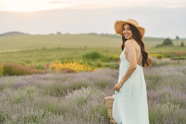 Jonge vrouw verzamelt lavendel in een mand — Stockfoto